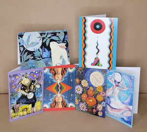 Collection of colorful greeting cards with artistic designs on a brown background
